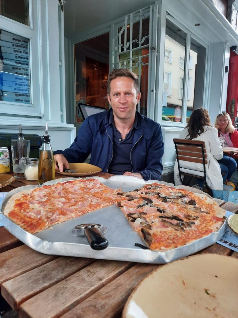 A photo of Eddie Morgan enjoying a huge pizza