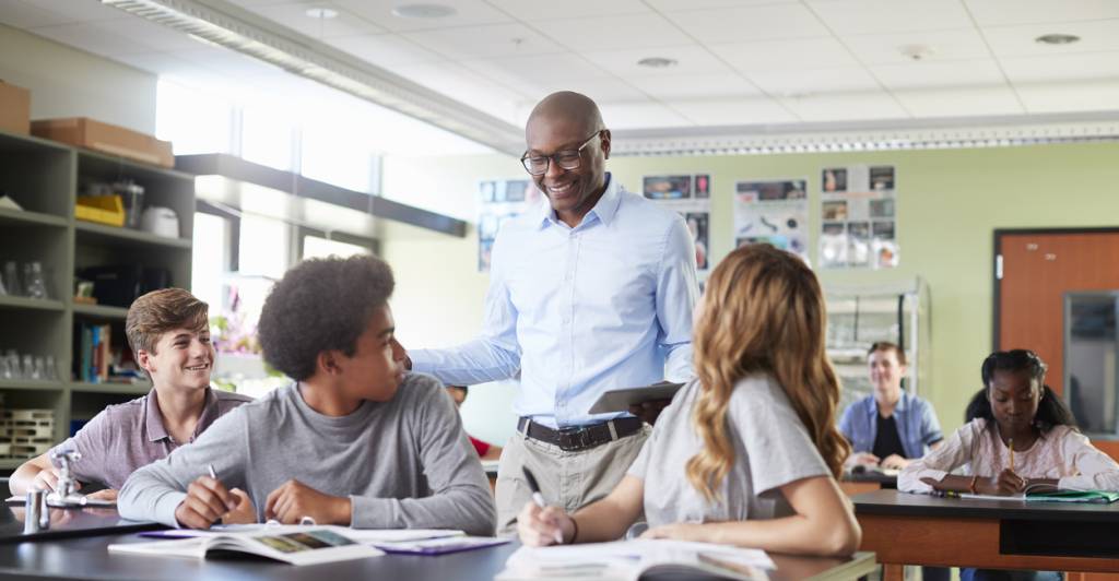 An image of a teacher staying mobile in their classroom while engaging with students