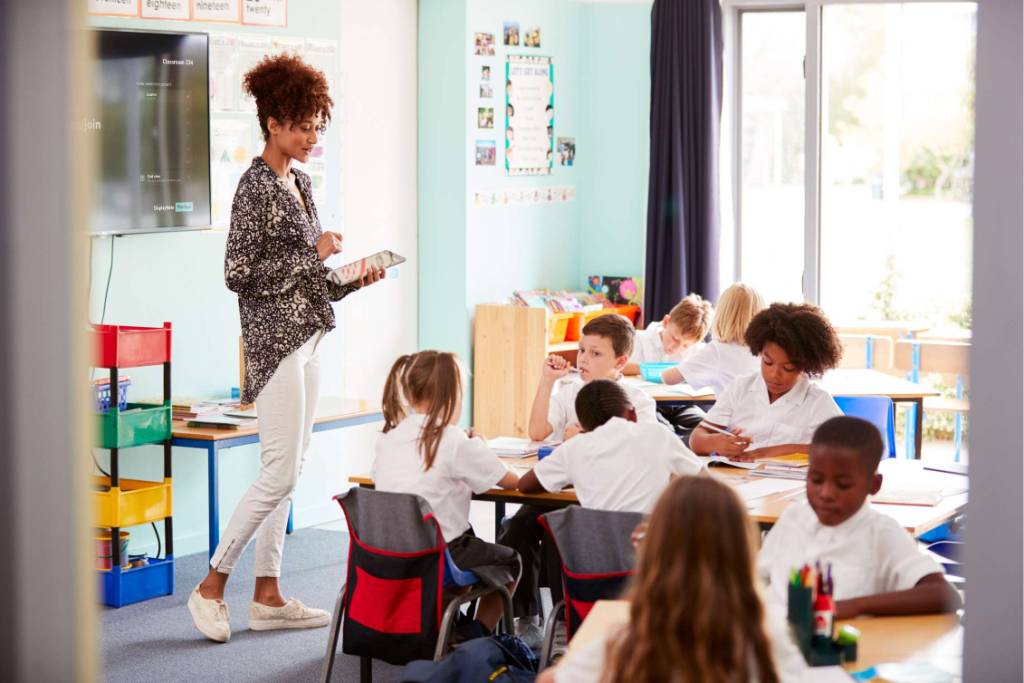 A teacher at the front on a classroom teaching a lesson using montage