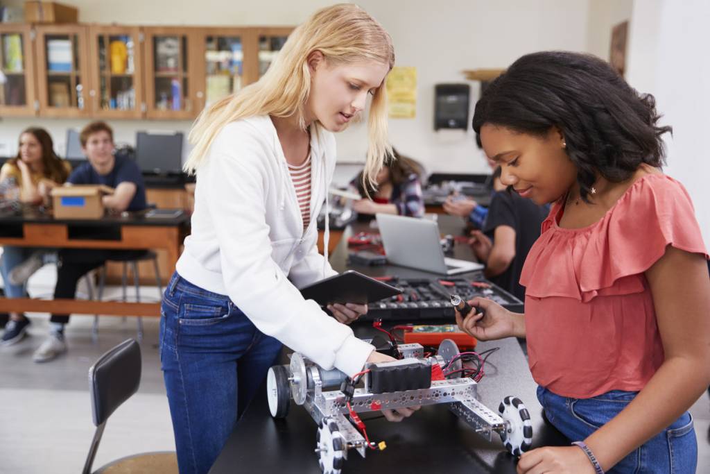 Two Female Pupils Building Robotic Vehicle In Science Lesson