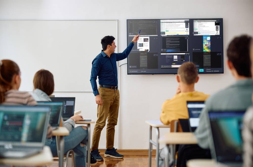 A teacher making use of the Extended Grid view functionality to allow up to 9 participants to share their work at once